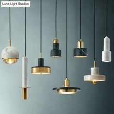 an assortment of pendant lights hanging from the ceiling in various colors and sizes, including marble