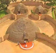 an aerial view of some huts with people standing in the doorways and on top