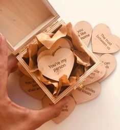 wooden hearts in a box that say you're my person and someone else is holding them