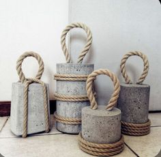 four cement containers with rope wrapped around them