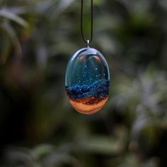 a glass ornament hanging from a tree filled with blue and orange stars in the sky