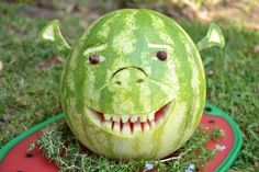 a watermelon carved to look like a creature with its mouth open and teeth missing