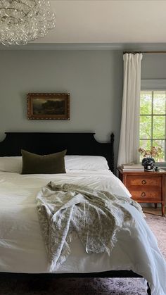 a bedroom with a large bed and chandelier