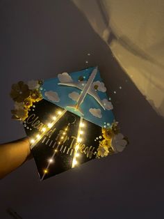 someone holding an umbrella with lights on it in the dark sky above clouds and stars