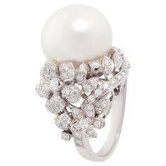 The South Sea pearl and diamond cocktail ring features a gem quality pearl of pinkish hues and 17.5mm diameter. The pearl is untreated. It displays a splendid nacre and its natural color and luster have not been enhanced in any way. The pearl is perched atop an arrangement of flowers set with 2.52 carats of top quality round diamonds (F/G-VVS, color, clarity and cut). The magnificent ring is one-of-a-kind. It was handmade in Italy by maestro Giuseppe according to an original design by Ella Gafter. It features craftsmanship of the highest refinement. The item is signed EG. Fancy Pink Diamond Ring, Pearl Cocktail Ring, Jar Jewelry, Diamond Bracelet Design, Diamond Cluster Earrings, Vintage Cocktail Ring, Diamond Cocktail Ring, Pearl And Diamond Ring, Pearl And Diamond Earrings