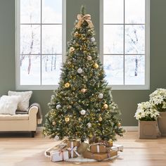 a decorated christmas tree in a living room with presents on the floor next to it