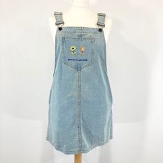 "Fun 1980s inspired denim dungaree Dress in a stonewashed denim fabric. The Dress Features an embroidered pocket on the front with the words 'believe In Yourself' and flowers.  Button fastening with adjustable straps.  In good condition. Measurements  Bib Front: 10\" widens to 15\" Waist: 40\" Length: 25\" from bib top Length: 30\"+ from shoulder with adjustable straps" Casual Embroidered Medium Wash Denim Dress, Retro Cotton Denim Dress With Pockets, 90s Blue Cotton Denim Jumpsuit, 90s Style Blue Cotton Denim Jumpsuit, Retro Blue Denim Dress With Pockets, Retro Cotton Denim Dress, Retro Cotton Denim Dress In Denim Blue, Retro Denim Blue Cotton Dress, 90s Style Blue Denim Overalls