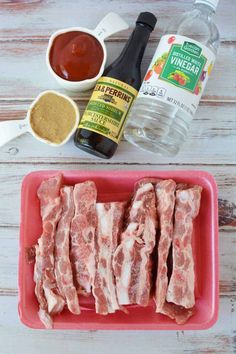 ingredients to make an appetizer laid out on a white wooden table including meat, seasoning and condiments