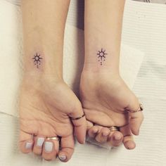 two people with matching tattoos on their feet, one is holding the other's hand