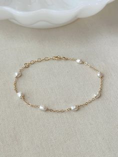 Please review the bracelet sizing guide below for the perfect fit! This dainty natural Pearl bracelet looks perfect for special occasions or can elevate any casual outfit. Each Pearl is hand wrapped skin friendly 14K Gold Filled or 925 Sterling Silver. Every bracelet comes with a small extender for adjustable sizing. You will feel sophisticated and chic when you put it on! * 4-5mm Freshwater Pearls * Pearl shape: round to oval, semi-irregular, semi-flat baroque * Dainty 14K Gold Filled Chain or Classic Delicate Chain Bracelet For Anniversary, Delicate Single Strand Gold Bracelet, 14k Gold Filled Bracelet For Anniversary, Classic Hypoallergenic Chain Bracelet For Anniversary, Delicate Gold Single Strand Bracelet, Delicate Chain Bracelet For Anniversary, Dainty Chain Bracelet For Wedding, Wedding Bracelets In 14k Yellow Gold Filled, Classic Hypoallergenic Wedding Bracelets