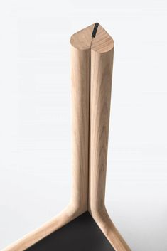 an object made out of wood on a white surface with one leg sticking out from the floor