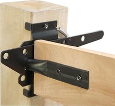 a pair of black metal brackets are attached to the side of a piece of wood