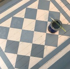 a blue and white checkered floor with a paint can on it