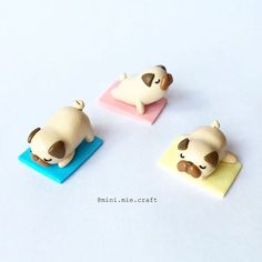 three small toy animals sitting on top of a blue and yellow mat with a white background