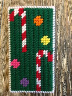 a crocheted square with flowers on it sitting on top of a wooden table