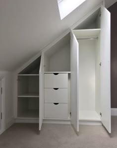 an attic bedroom with white closets and shelves