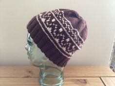 a brown and white knitted hat sitting on top of a head