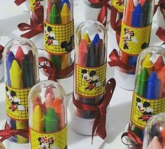 many different colored crayons in glass containers with bows on the sides and mickey mouse