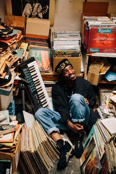 a man sitting on the ground surrounded by records