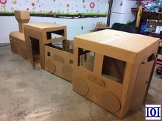 two cardboard train cars sitting on top of a garage floor