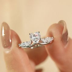 a person holding a diamond ring in their hand