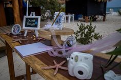 a table topped with lots of items on top of a wooden table next to the ocean