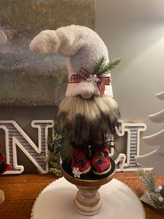 a christmas decoration on top of a table in front of a wall with the word north written above it