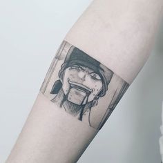 a person's arm with a black and white drawing of a woman sticking out her tongue