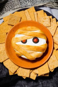 a plate with crackers wrapped around it and eyes