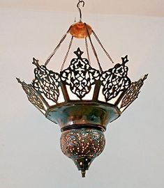 an ornate chandelier hanging from the ceiling in a room with white walls and flooring