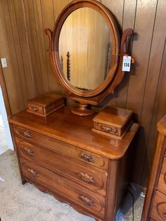 an antique dresser and mirror in a room