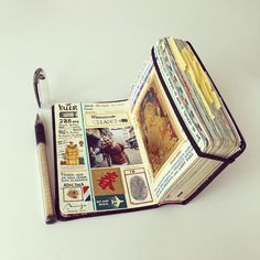 an open book with pictures on it next to a pen