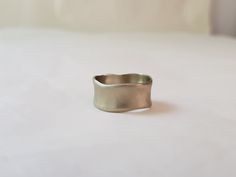 a silver ring sitting on top of a white surface