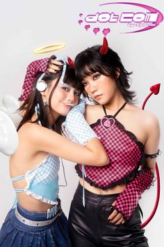 two women in costumes are posing for a photo with devil horns on their heads and ears