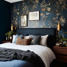 a bedroom with blue walls and floral wallpaper on the bed, along with two framed pictures