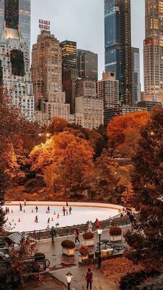 people skating on an ice rink surrounded by tall buildings