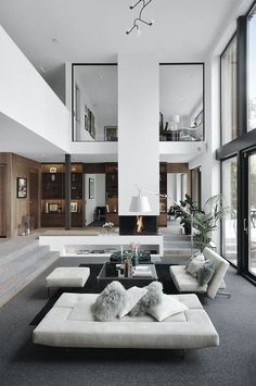 a living room with couches, tables and windows in the wall to the outside