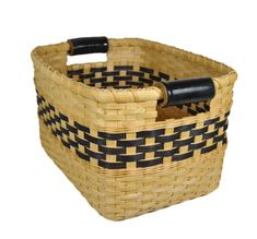 a woven basket with black handles on a white background