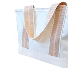 Product Details: This Cabana tote is the ultimate beach bag sun-seeker. With its spacious interior, this tote is perfect for carrying all your beach or pool essentials, from towels and sunscreen to snacks and drinks. This bag is durable and made of a waterproof fabrication. We think this bag changes the beach game. It is so chic, yet so useful. Dimensions 12.5”H x 21.5” W x 8”D Handle Drop 11" Made from 18.5oz tear and water-proof vinyl-coated nylon. Sporty Tote Weekender Bag With Adjustable Strap, White Canvas Bag For Spring Travel, Sporty Canvas Tote Bag For Everyday Use, Sporty Large Capacity Canvas Tote Bag, Sporty Everyday Canvas Tote Bag, Sporty Everyday Tote Canvas Bag, Sporty White Nylon Shoulder Bag, Casual Nylon Tote Weekender Bag, Sporty Rectangular Canvas Bag