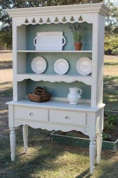 a white china cabinet with plates on it