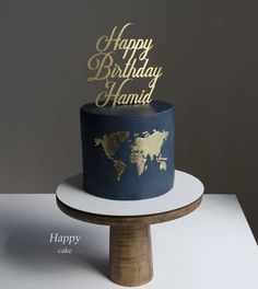 a blue and gold birthday cake sitting on top of a wooden stand with the words happy birthday hannah