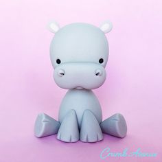 a small white toy sitting on top of a pink floor next to a purple wall