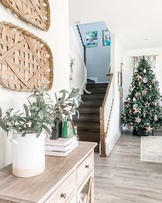 a christmas tree is on the wall next to some stairs