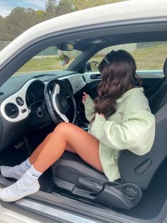 a woman sitting in the driver's seat of a car