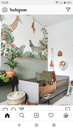 a baby's room with a giraffe mural on the wall and other decorations