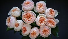 a bunch of pink flowers sitting in a vase on top of a black tablecloth