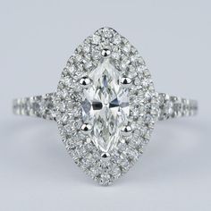 an oval cut diamond ring with halos and pave set diamonds on the band