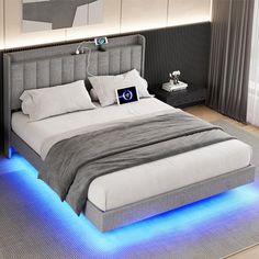 a large bed with blue lights on the sides and headboard is in a room