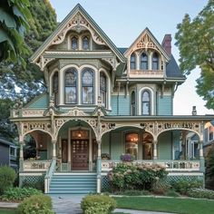 an old victorian style house with green trim and blue sidings on the front porch