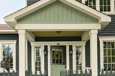 a green and white house with two front doors